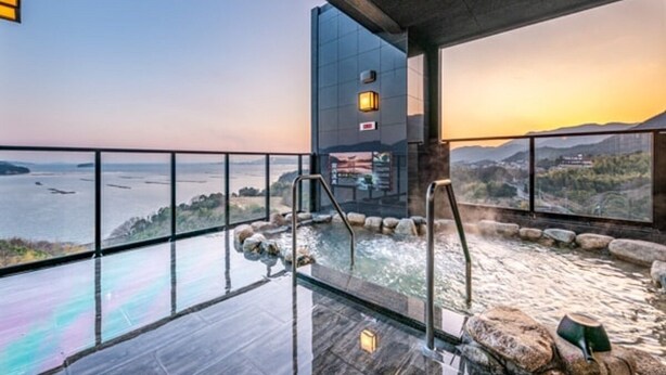 Een moderne spa met een glazen hottub met uitzicht op een prachtig waterlichaam.