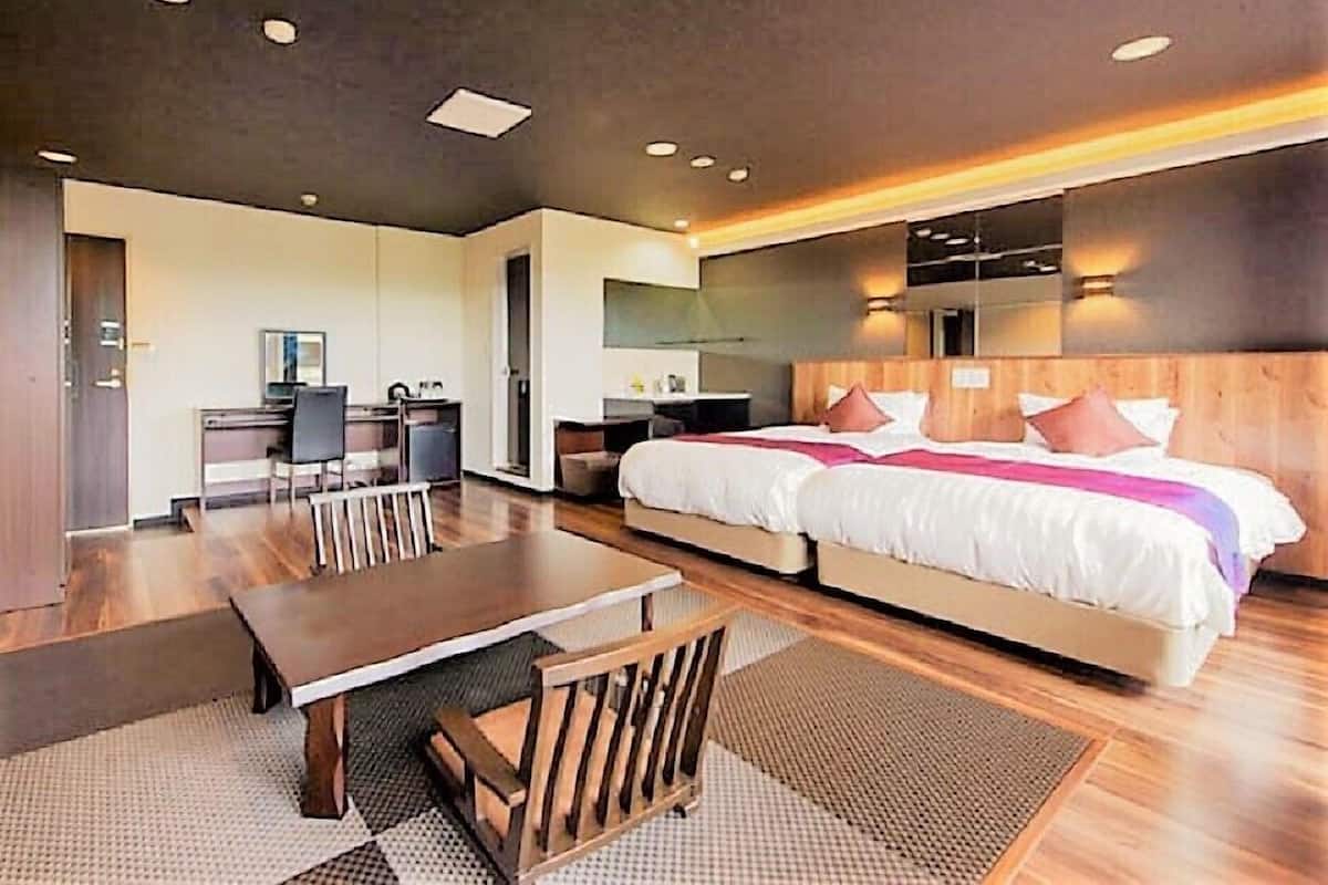 Een moderne hotelkamer met een groot bed, een bureau en een zithoek.