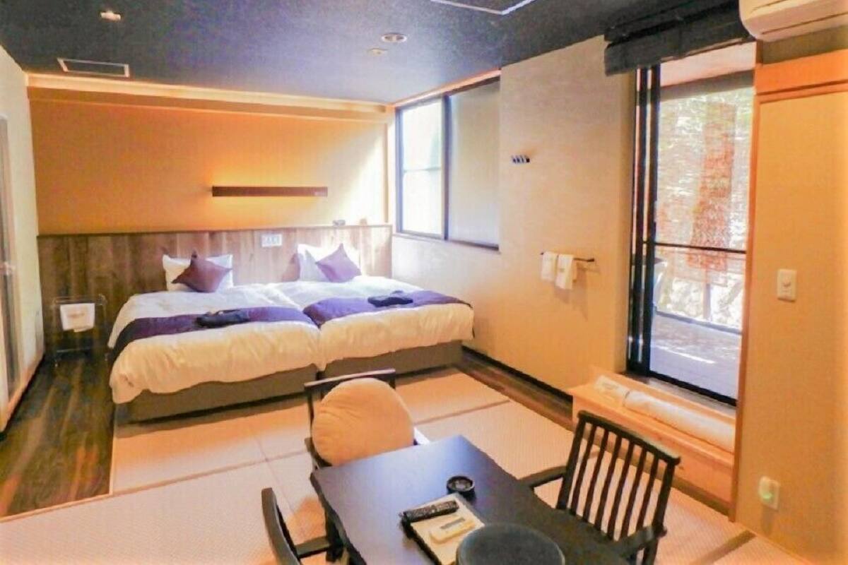 Een hotelkamer met twee bedden, een tafeltje en een raam.