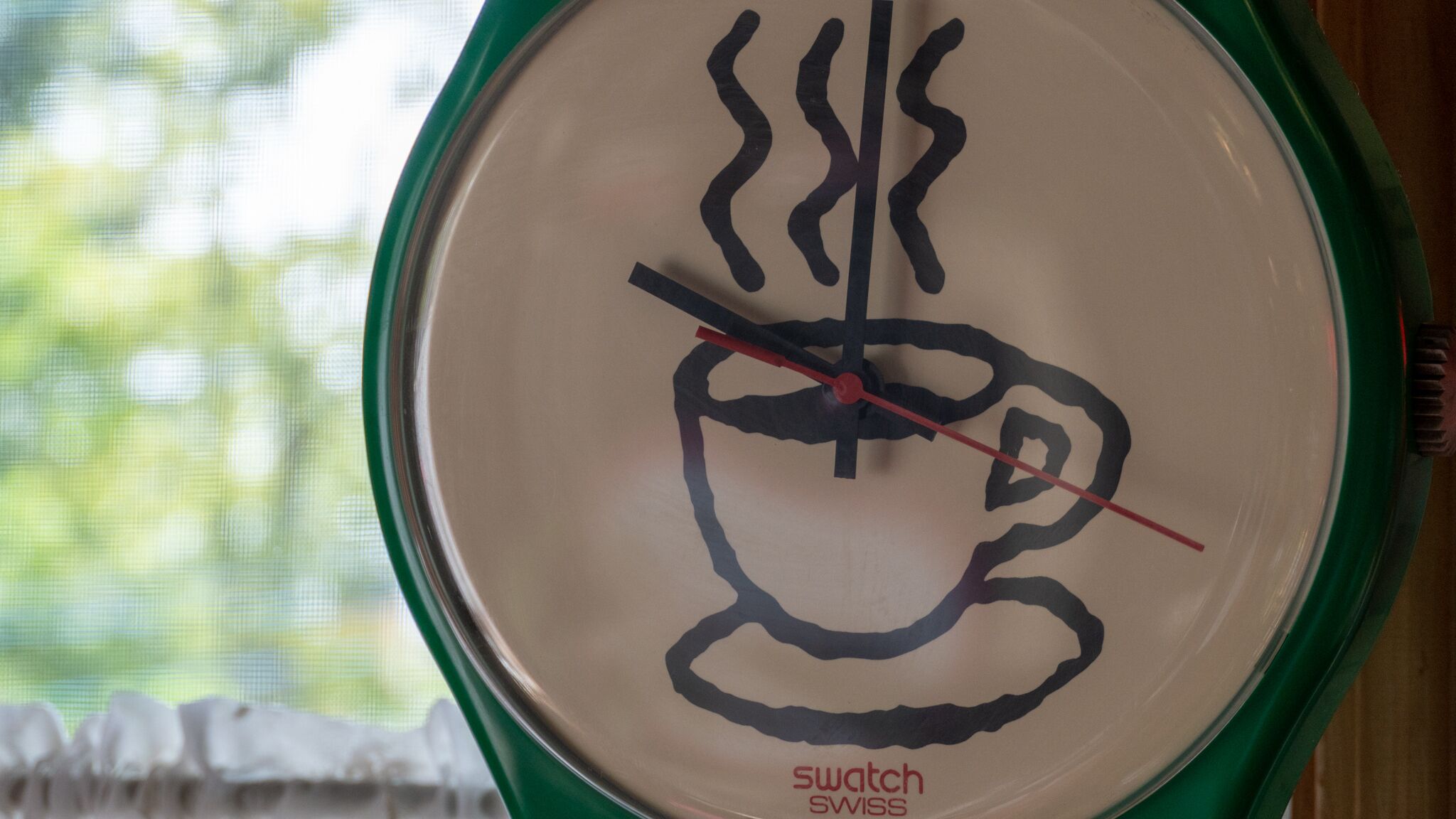 Un reloj Swatch suizo con un diseño único que presenta una taza y líneas de vapor.