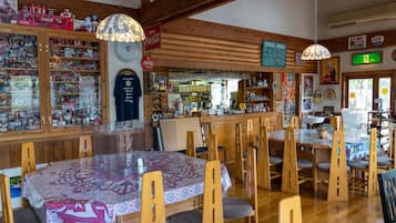 Un accogliente ristorante con interni in legno, un tavolo rotondo con sedie e diversi articoli da collezione Coca-Cola.
