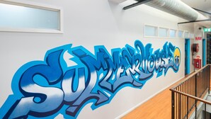 A hallway with a graffiti wall featuring the text "Superhouse." - Summer House Brisbane - Hostel (Brisbane)