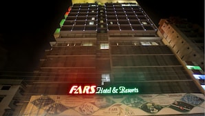 Ein Hotel mit mehreren Etagen, beleuchteten Fenstern und einer gut sichtbaren Schilder für FARS Hotel & Resorts.