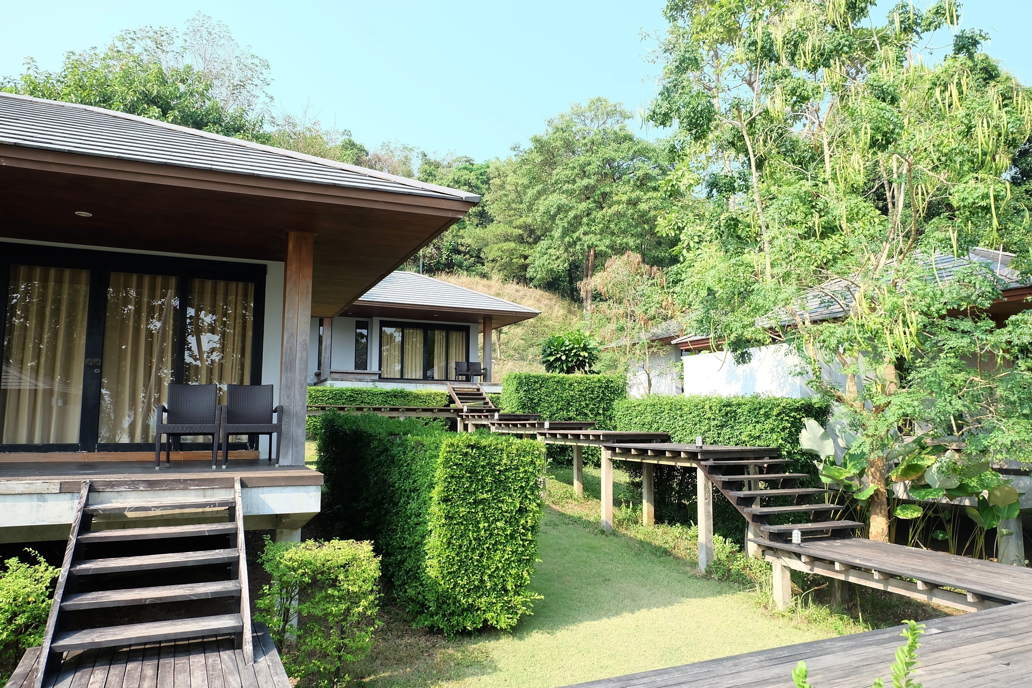 A resort with a wooden deck, a covered seating area, and a well-maintained garden.
