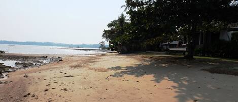 A sandy beach with a clear view of the water and distant land.