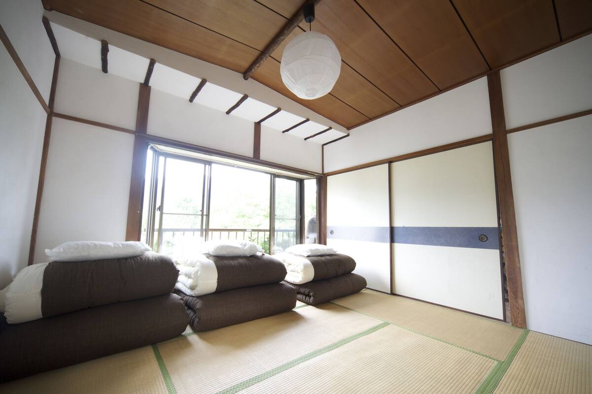 Ein traditioneller japanischer Raum mit Tatami-Boden, einer Shoji-Schiebetür und einer hängenden Papierlaterne.