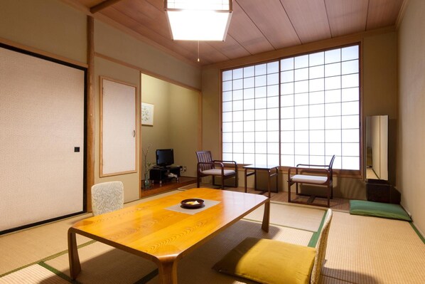 Ein traditioneller japanischer Raum mit Tatami-Böden, einem niedrigen Holztisch und Schiebetüren.
