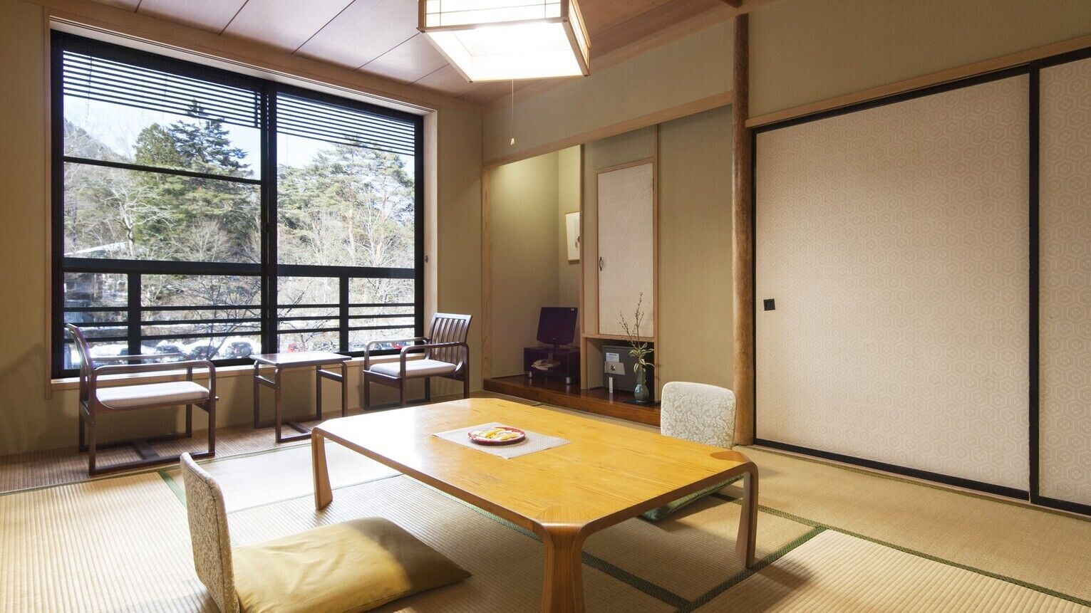 A traditional Japanese room with tatami flooring, a low wooden table, and sliding doors.