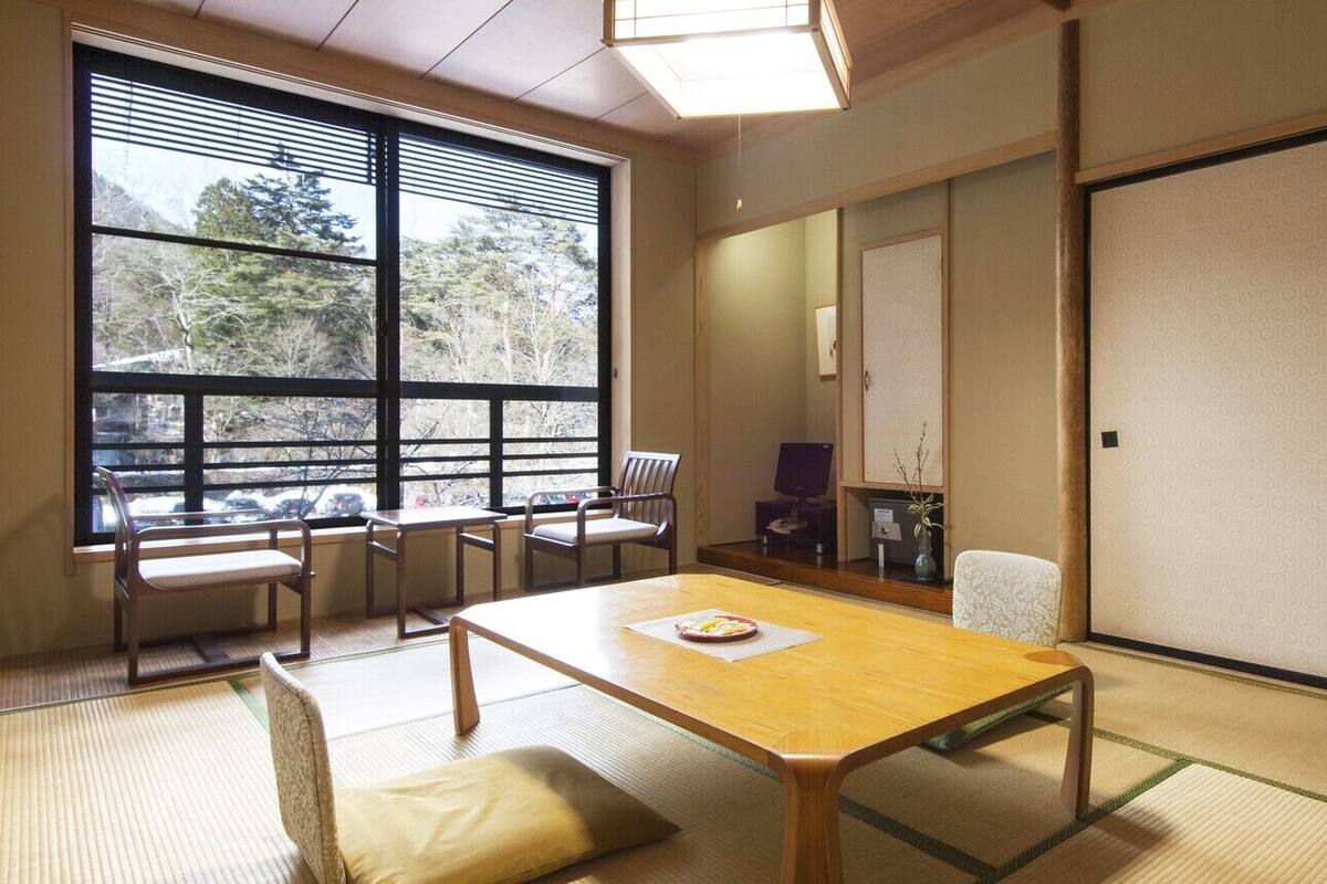 Ein traditioneller japanischer Raum mit Tatami-Böden, einem niedrigen Holztisch und Schiebetüren.