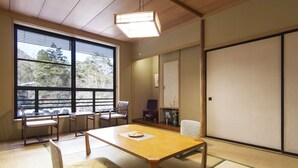 A traditional Japanese room with tatami flooring, a low wooden table, and sliding doors. - Hotel Seikoen (Nikko)