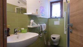 Un baño con lavamanos, inodoro y ducha.