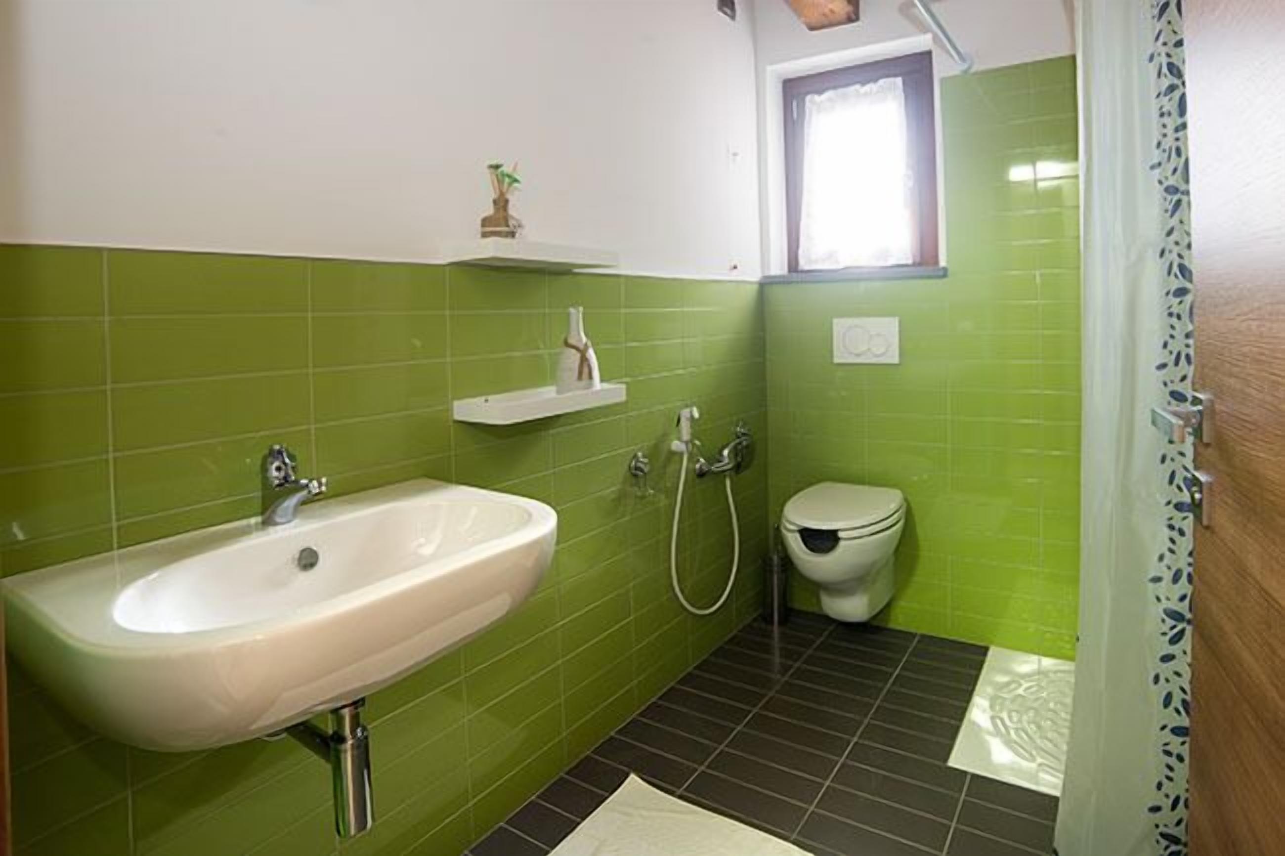 Un baño con lavamanos, inodoro y ducha.