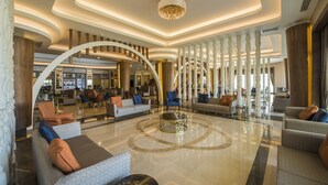 A spacious lobby with a central coffee table, seating areas, and a modern chandelier. - Dream World Aqua Hotel - All Inclusive (Manavgat)