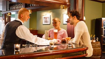 Un espace bar où un barman sert des boissons aux clients.