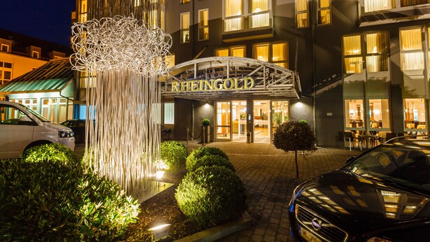 Entrada de hotel con un arco decorativo y una fuente.
