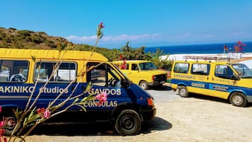 Tour buses line the sandy beach, offering scenic views of the sea.