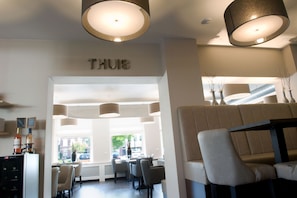 A modern interior with a seating area, a bar, and a visible sign that reads "THUIS". - Hotel-Restaurant Thuis! (Dinteloord)