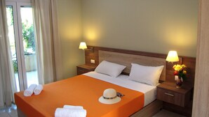 Une chambre d’hôtel avec un lit, deux lampes de chevet, une table de nuit et une fenêtre avec des rideaux.