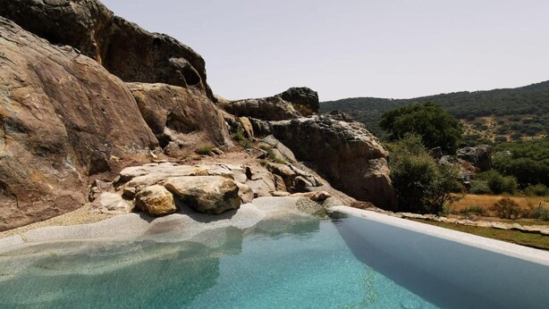 A clear pool with a rocky landscape and hills in the background. - Tambor del Llano (Grazalema)