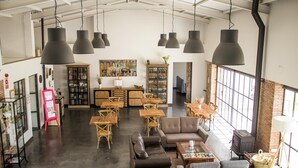 A spacious cafe with high ceilings, exposed brick walls, and large windows. - Tambor del Llano (Grazalema)