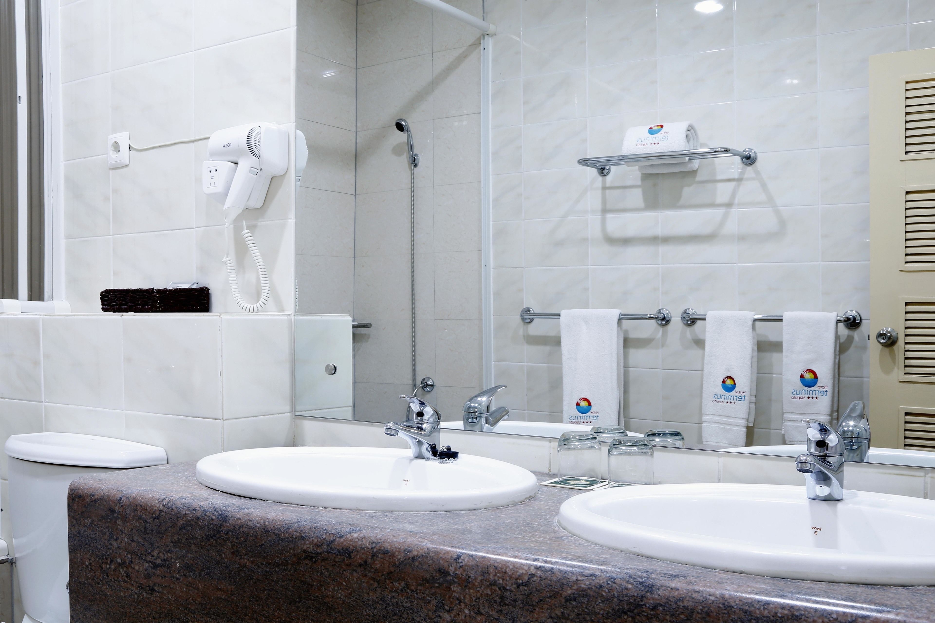 Un bagno con due lavabi, un asciugacapelli e un porta asciugamani.