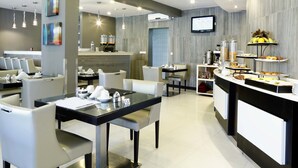 A modern hotel lobby with a reception desk, seating area, and buffet. - Hotel Terminus (Maputo)