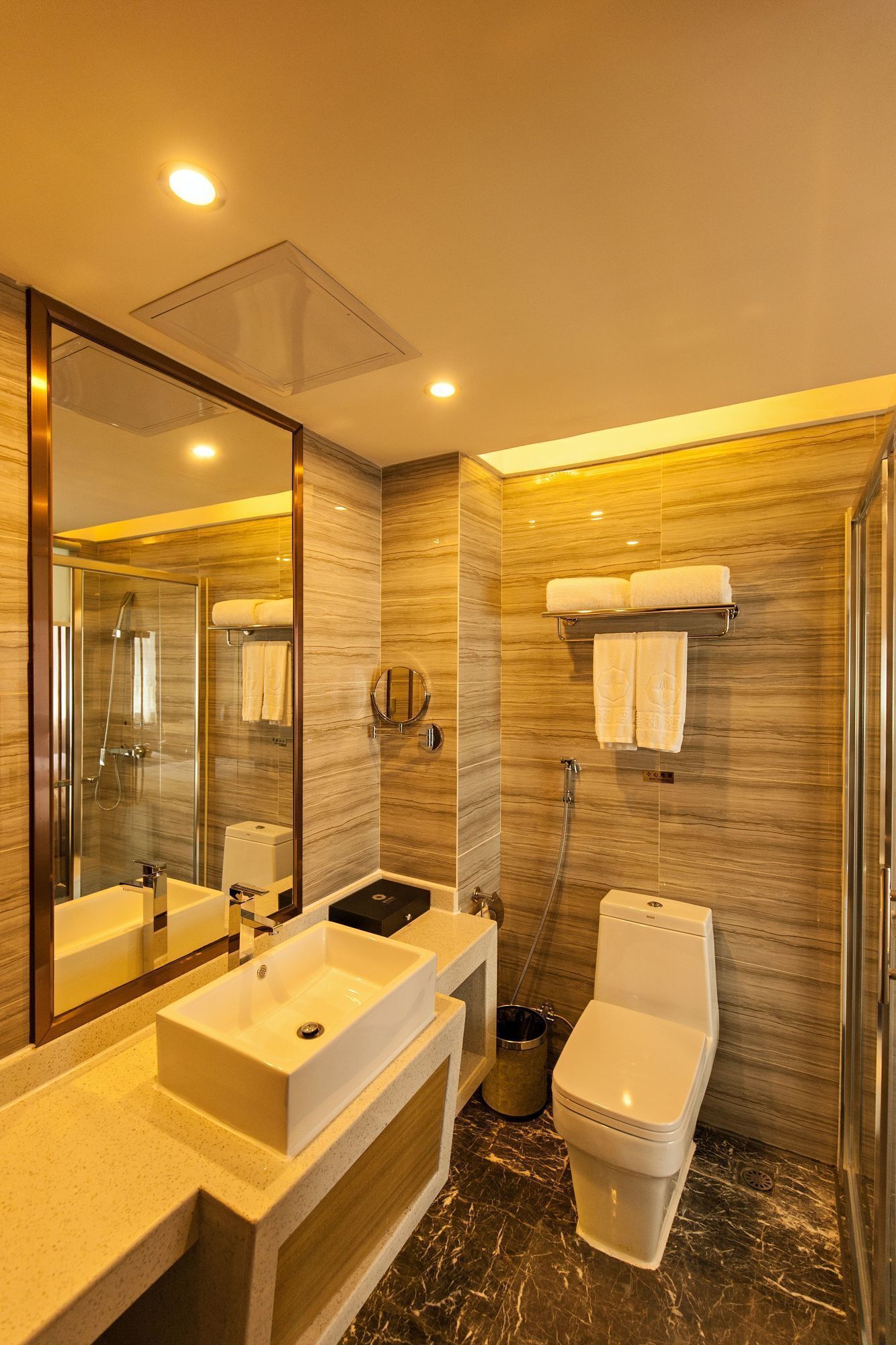 A modern bathroom with a large mirror, two sinks, a toilet, and a shower.