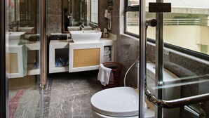 A modern bathroom with a glass shower enclosure, a white sink, and a toilet.