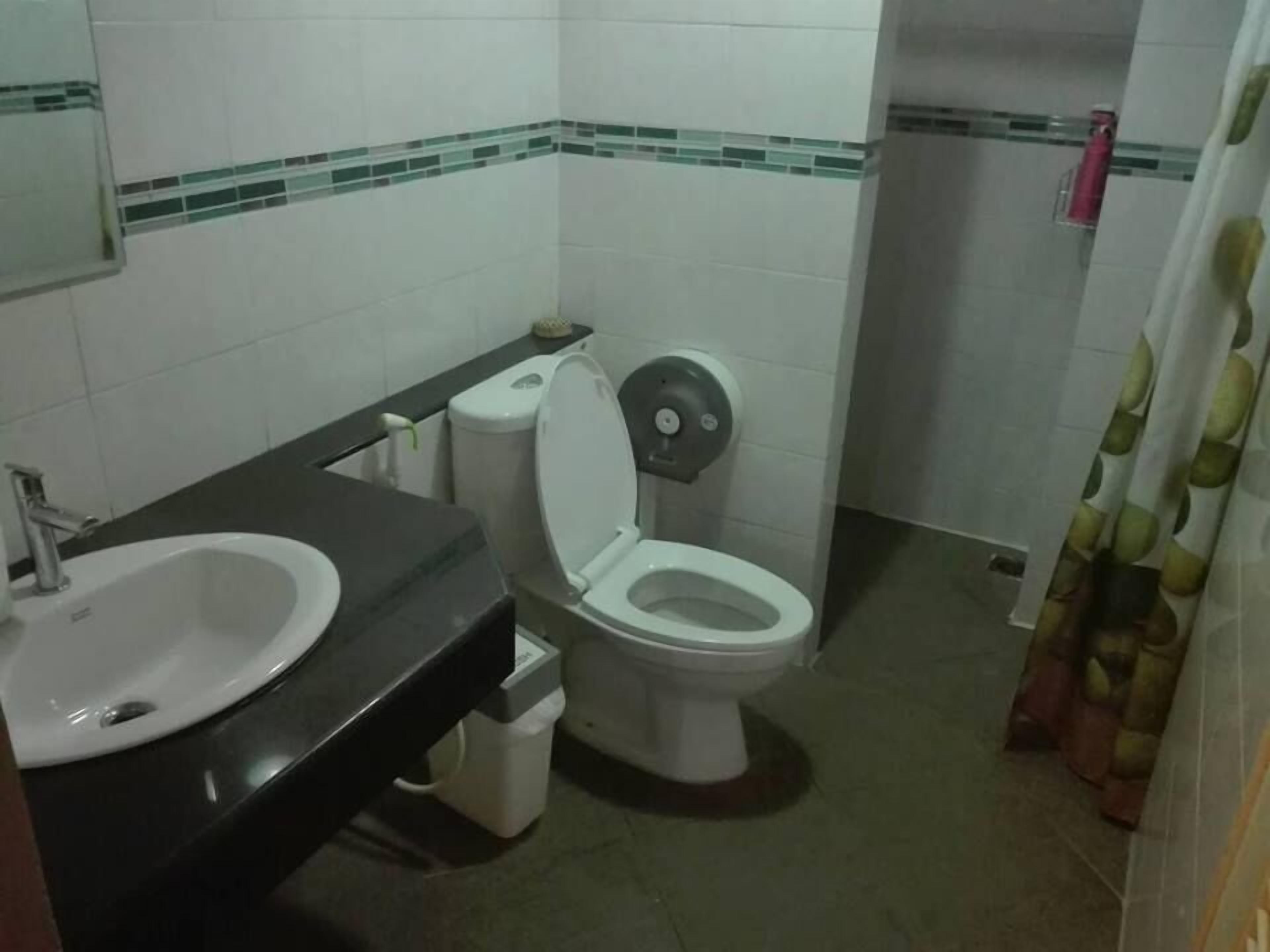A bathroom with a sink, toilet, and bidet.