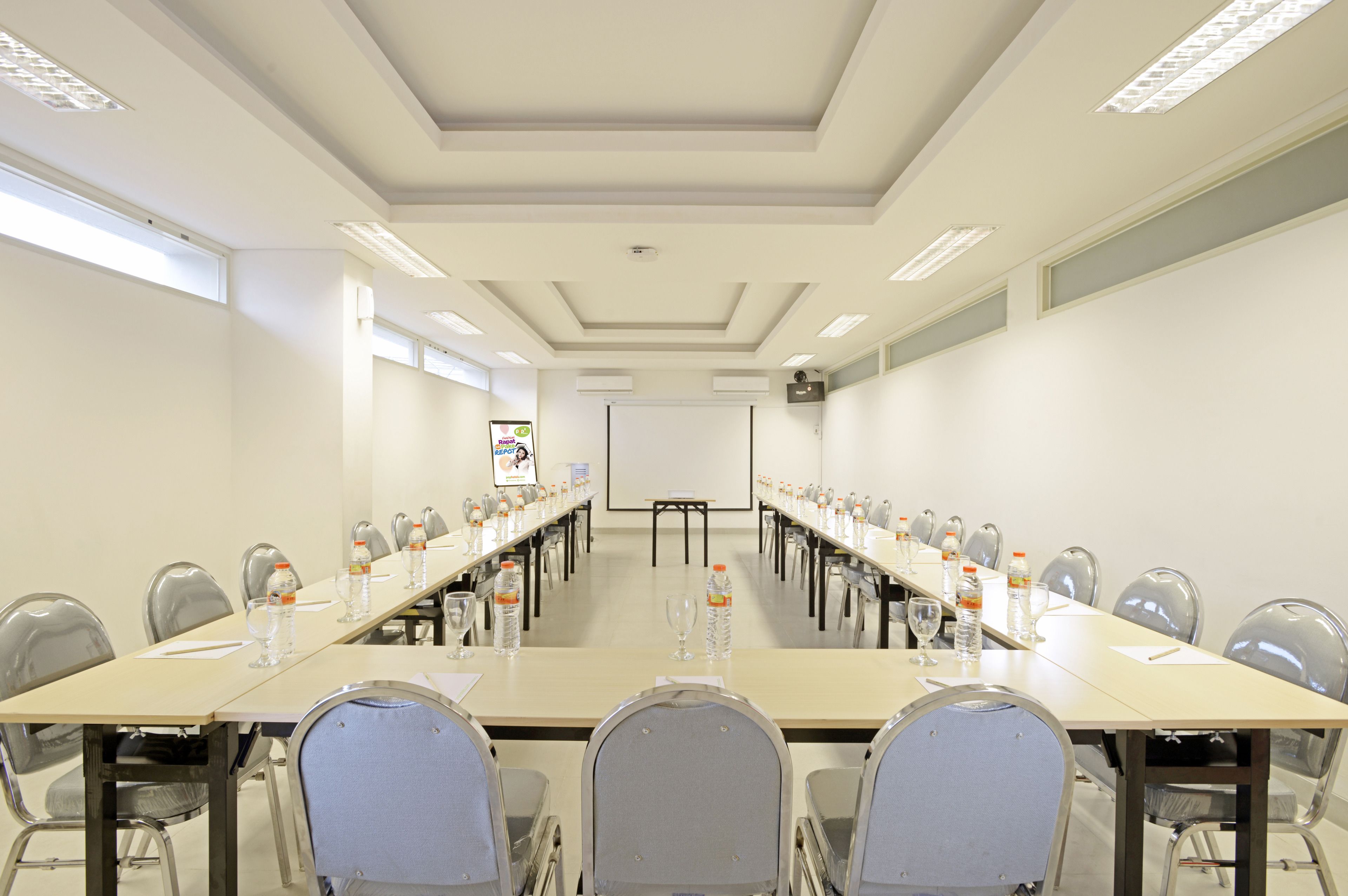 A conference room with a long table, chairs, and water bottles.