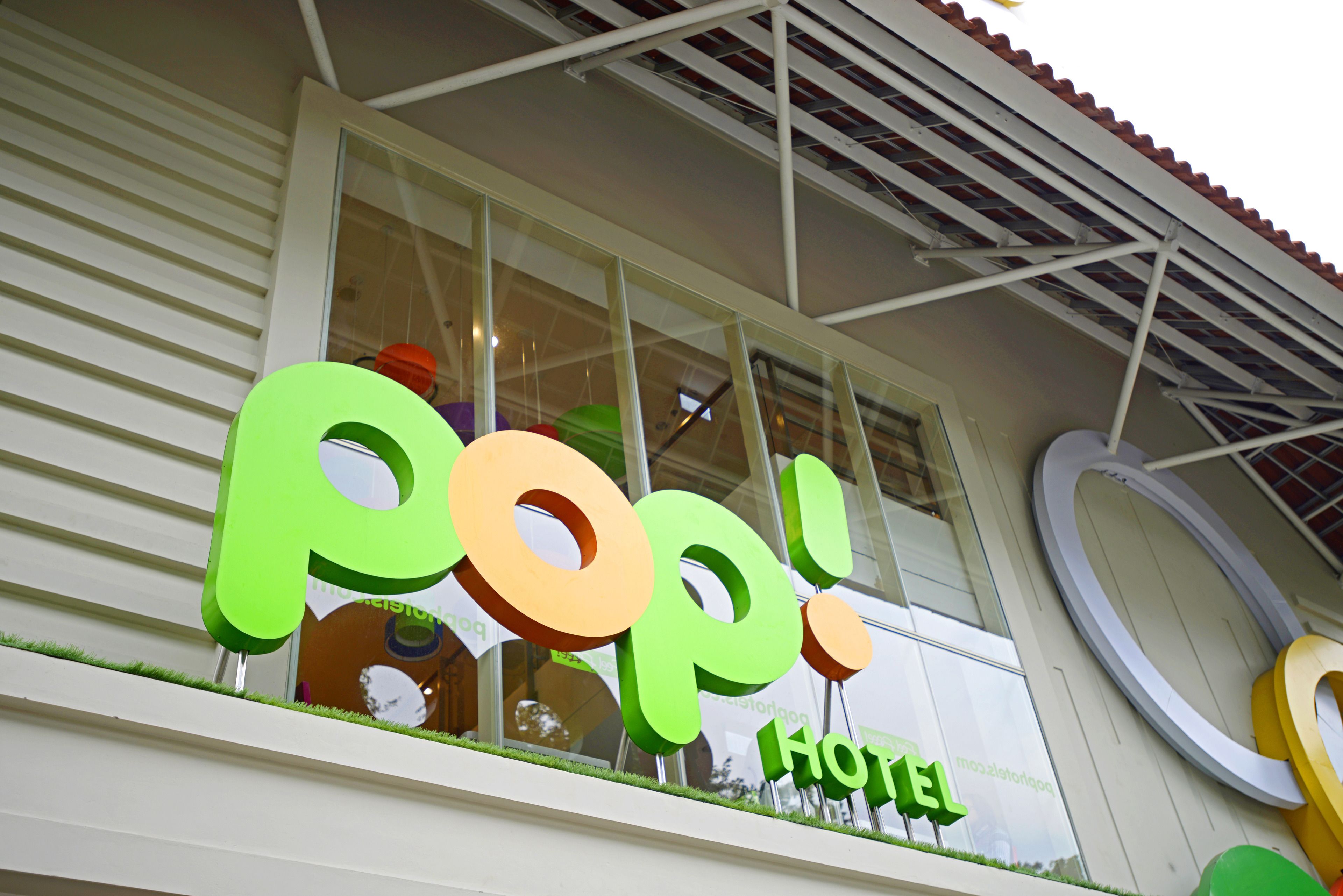 Ein Hotelschild mit großen, farbenfrohen Buchstaben, die "Pop! Hotel" zeigen.