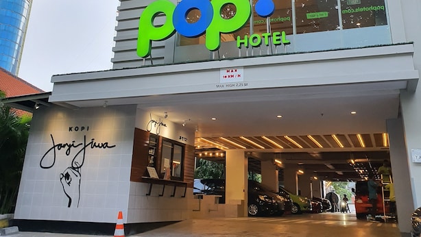 A hotel named 'Pop! Hotel' with a modern design, a visible hand-painted sign, and a covered entrance area. - POP! Hotel Diponegoro Surabaya (Surabaya)