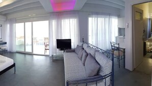 Une chambre d’hôtel moderne, dotée d’un grand lit, d’un canapé, d’un bureau et d’une télévision.