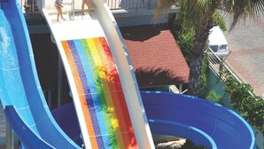 Um toboágua com várias pistas e design de arco-íris, que deságua numa piscina.