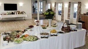 A buffet table with various food items and a television mounted on the wall. - Hotel Højgaarden (Fjerritslev)