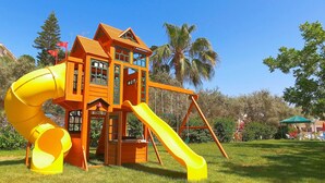 A playground with a yellow slide and a climbing structure. - Hadjios Valley (Mazotos)