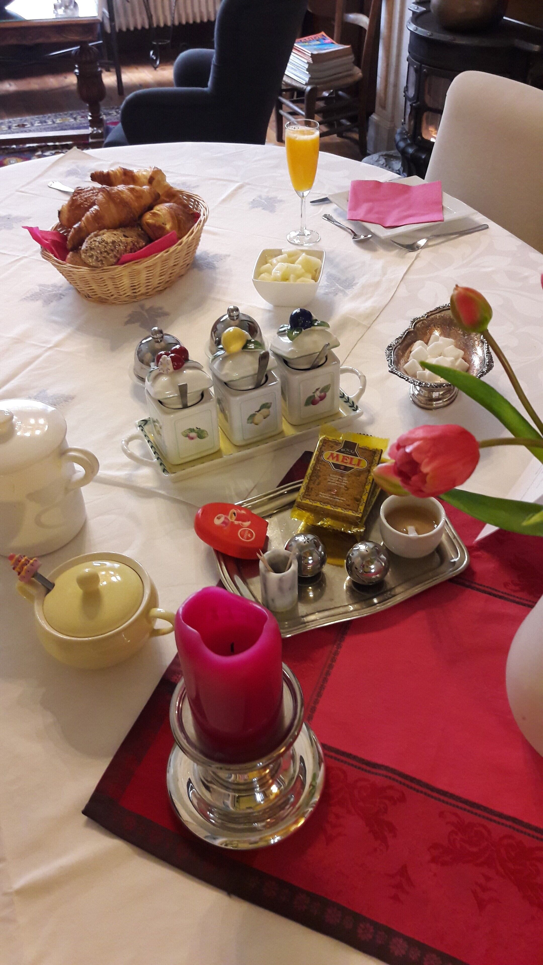 A table set with various breakfast items including pastries, fruits, and condiments.
