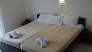 A double bed with two white towels and a nightstand with a lamp. - Porto Marathos (Trifylia)