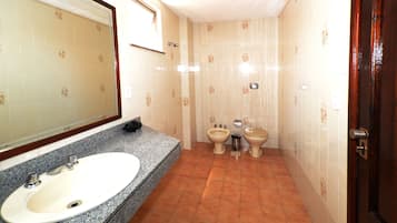 Casa de banho com lavatório, bidé e sanita.