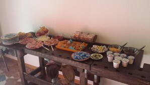 A buffet table with various food items including meats, fruits, and pastries. - Luci a San Siro (Milan)