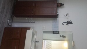 A kitchen with wooden cabinets, a towel rack, and a wall-mounted towel dispenser. - Luci a San Siro (Milan)