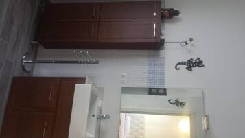 A kitchen with wooden cabinets, a towel rack, and a wall-mounted towel dispenser.