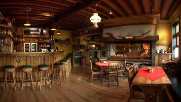 A rustic bar area with wooden stools, a bar counter, and a fireplace.