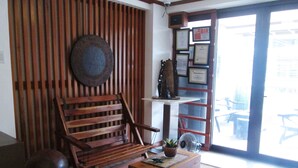 A wooden bench, a small table with a plant, and a wall with certificates.