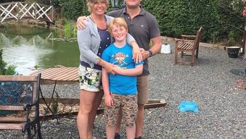 Family enjoys a serene moment in the garden, surrounded by a tranquil pond and lush greenery.