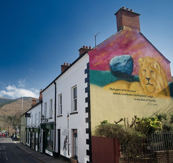 A building with a mural of a lion and a quote by C.S. Lewis.