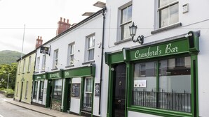 A row of buildings with green awnings, including a bar named Crawfords Bar. - The Rostrevor Inn (Newry)