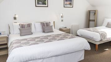 Un dormitorio con dos camas, un espejo grande y dos luces fijadas a la pared.