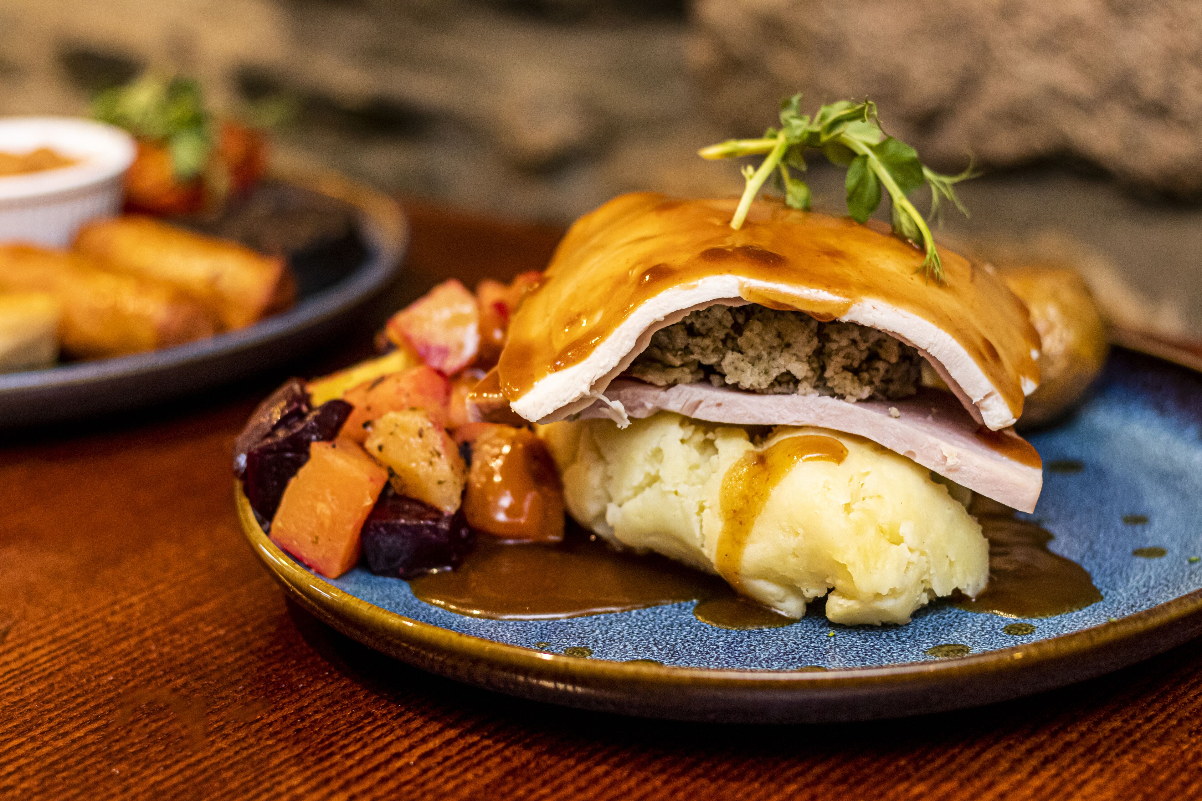 A plate of food with a sandwich, mashed potatoes, and gravy.