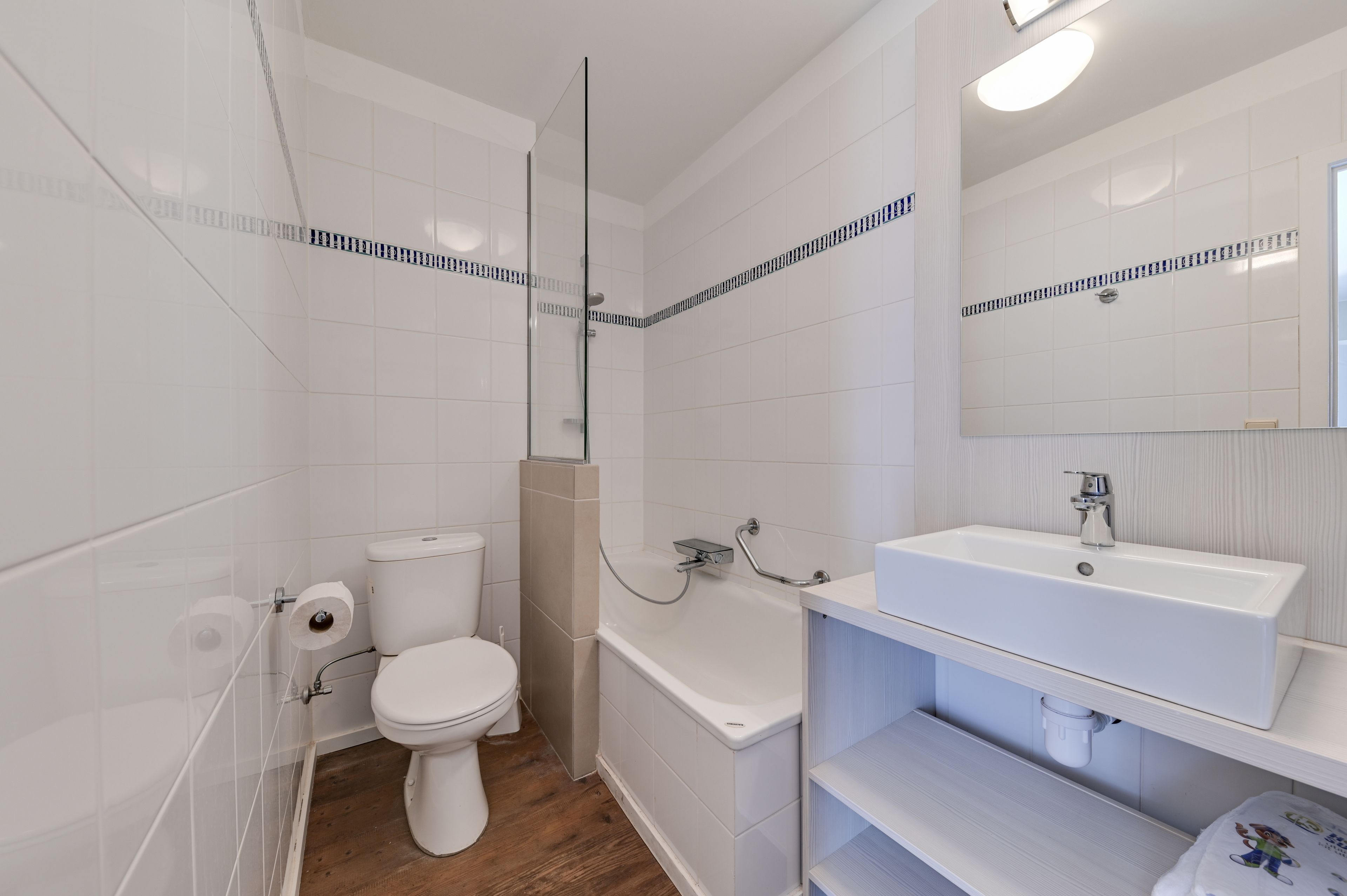 Une salle de bain moderne équipée de toilettes, d’une baignoire et d’un lavabo.